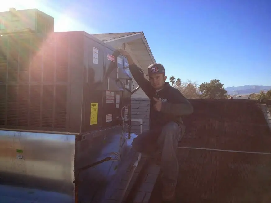 HVAC technician performing AC Tune-Up on a rooftop unit in Dover